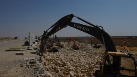 Excavator arm above the rock face during breaking works at BeauRivage Plaza