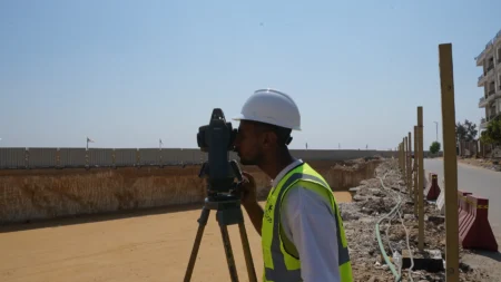 Surveyor setting out levels with a total station at BeauRivage Plaza